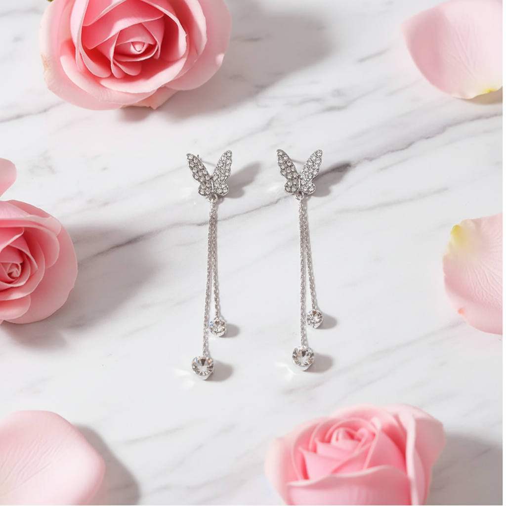 Crystal butterfly earrings flat lay with rose petals